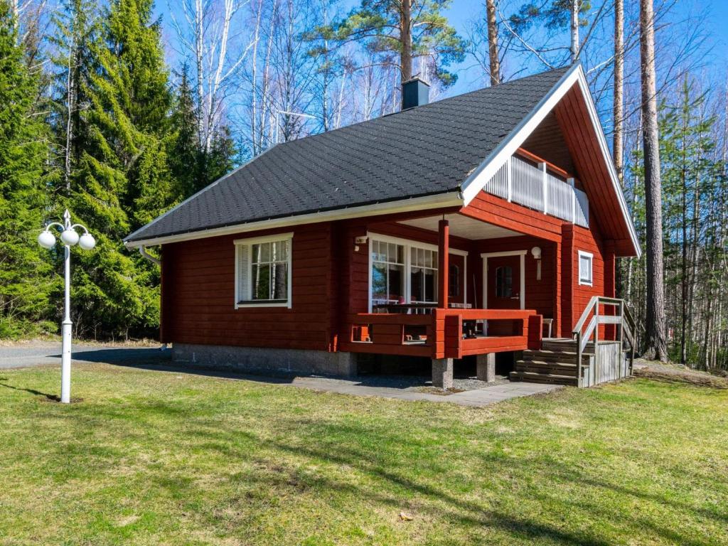 una piccola cabina rossa con tetto nero di Holiday Home Pinea by Interhome a Niittymaa