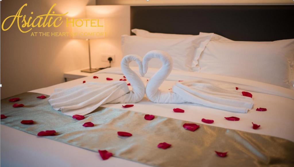 Postel nebo postele na pokoji v ubytování Asiatic Hotel