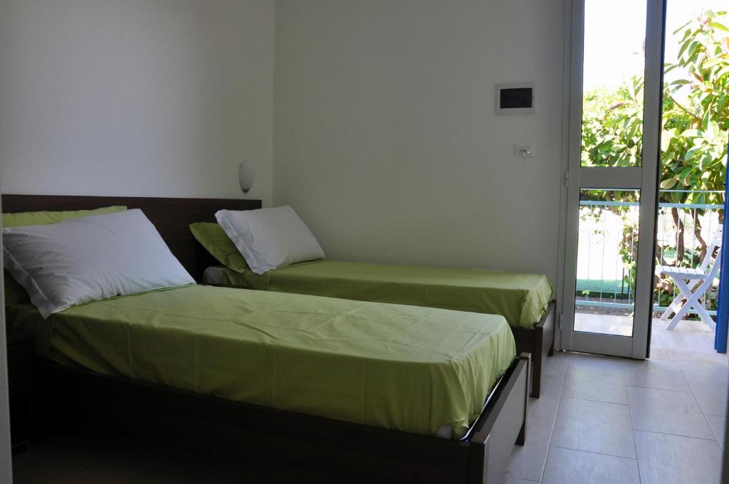 a bedroom with two beds and a balcony at Villa Lara in Polignano a Mare