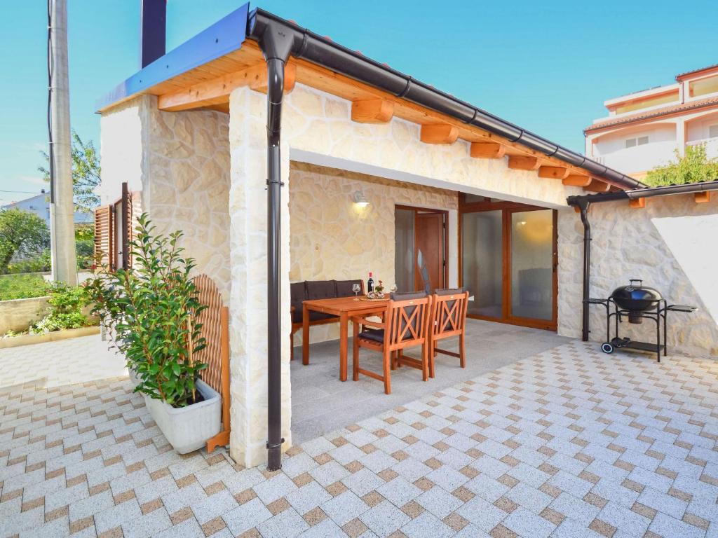 Un patio con mesa de madera y parrilla. en Holiday Home Ante by Interhome, en Brodarica