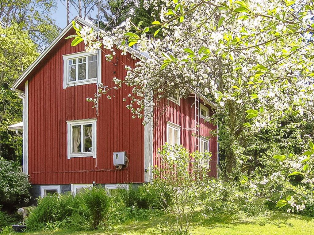 a red house with white windows and trees at Holiday Home Archipelago red cottage by Interhome in Dragsfjärd