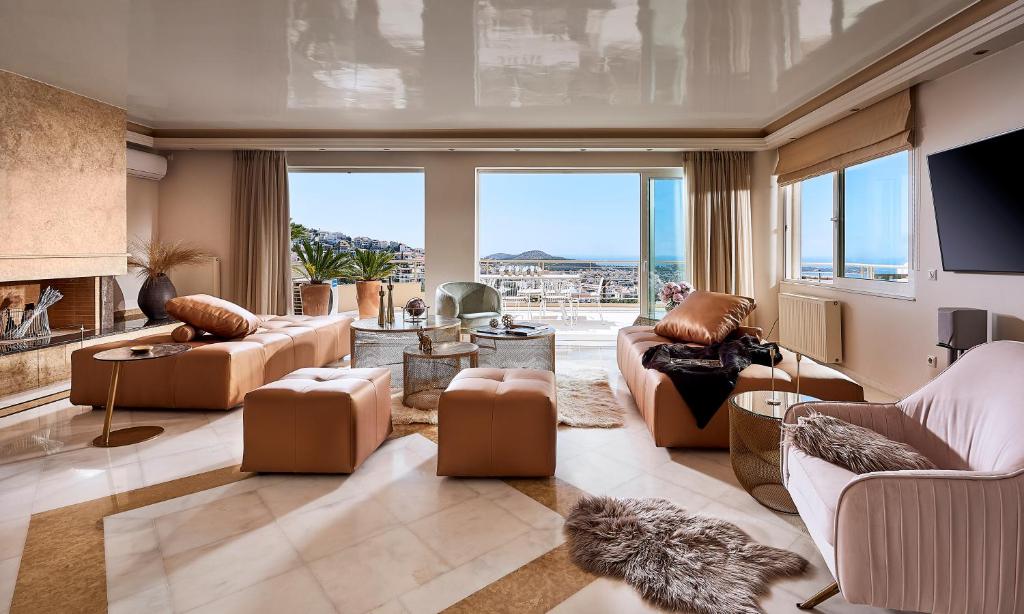 a living room with couches and a large window at Elaia Luxury Residences in Athens