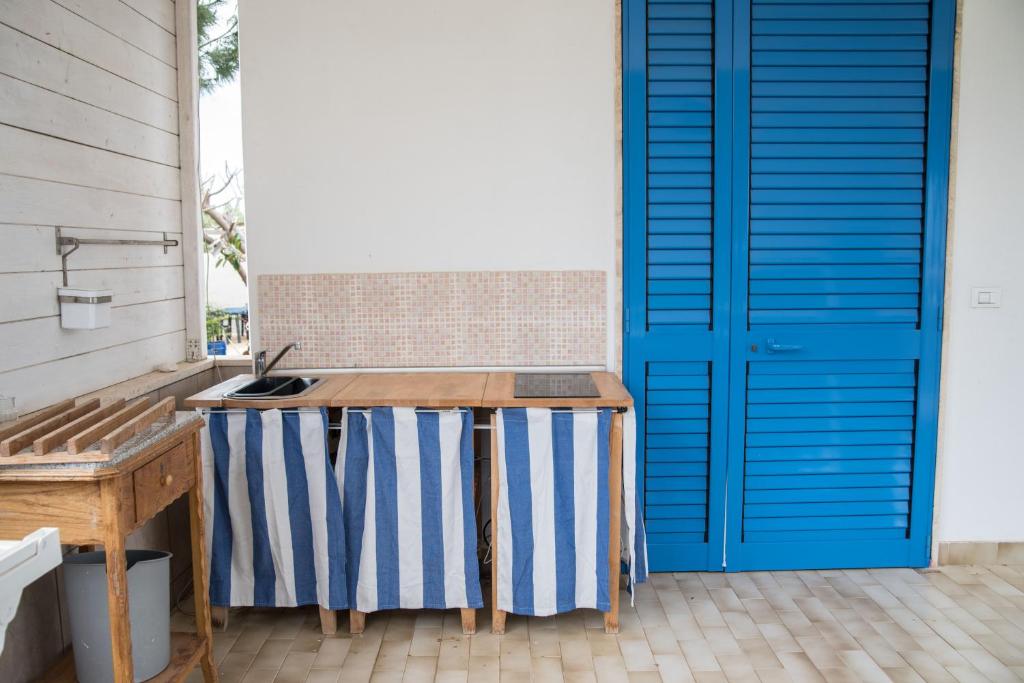 a patio with a table and a blue door at Villa Lara in Polignano a Mare