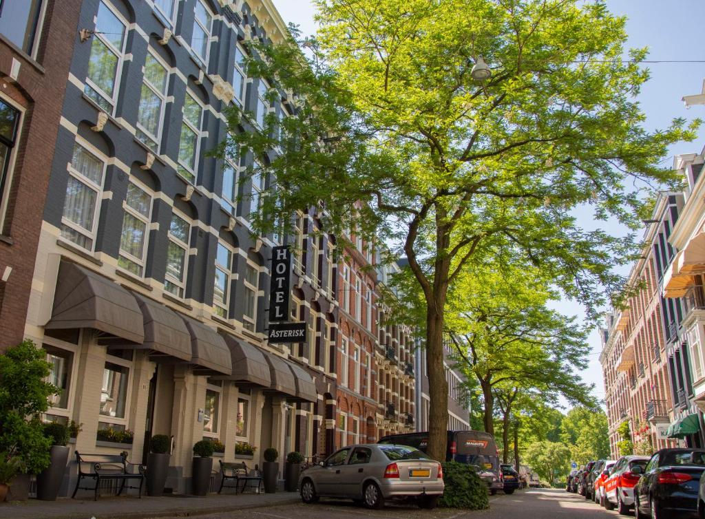 eine Straße in einer Stadt mit Gebäuden und Autos in der Unterkunft Hotel Asterisk, a family run hotel in Amsterdam