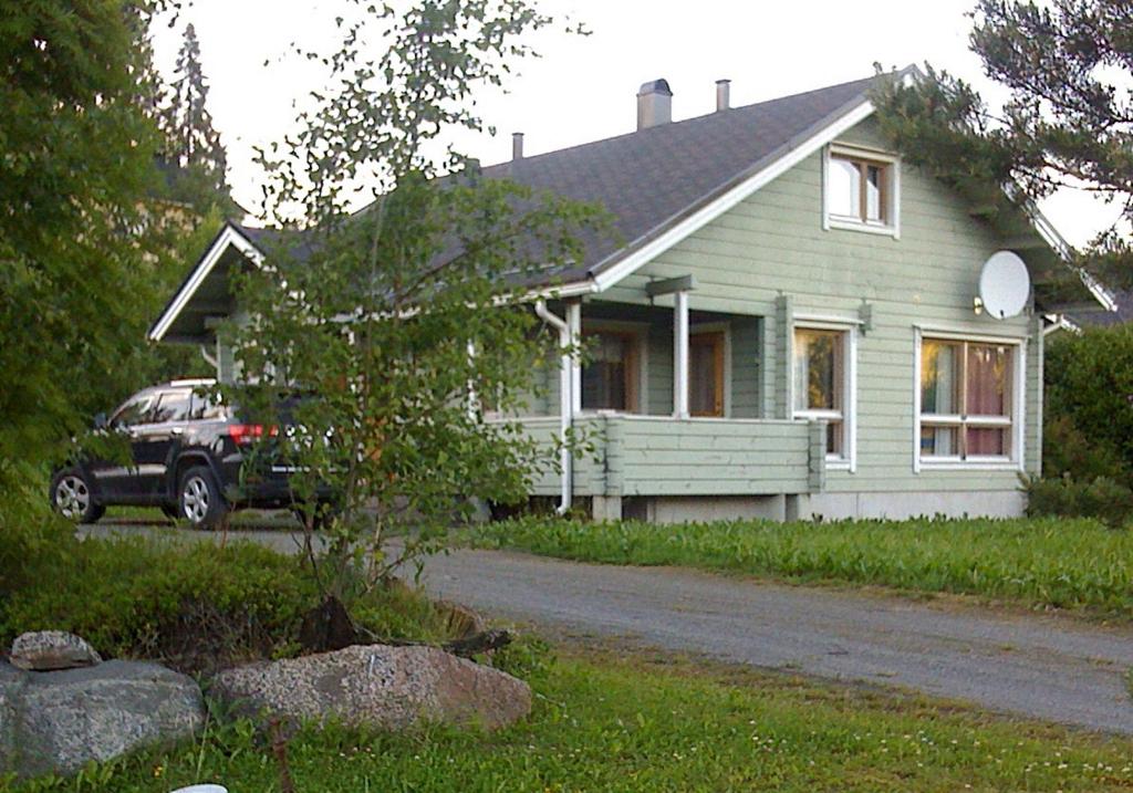 Cottage Nuppulanranta في يامسا: منزل فيه سيارة متوقفة أمامه