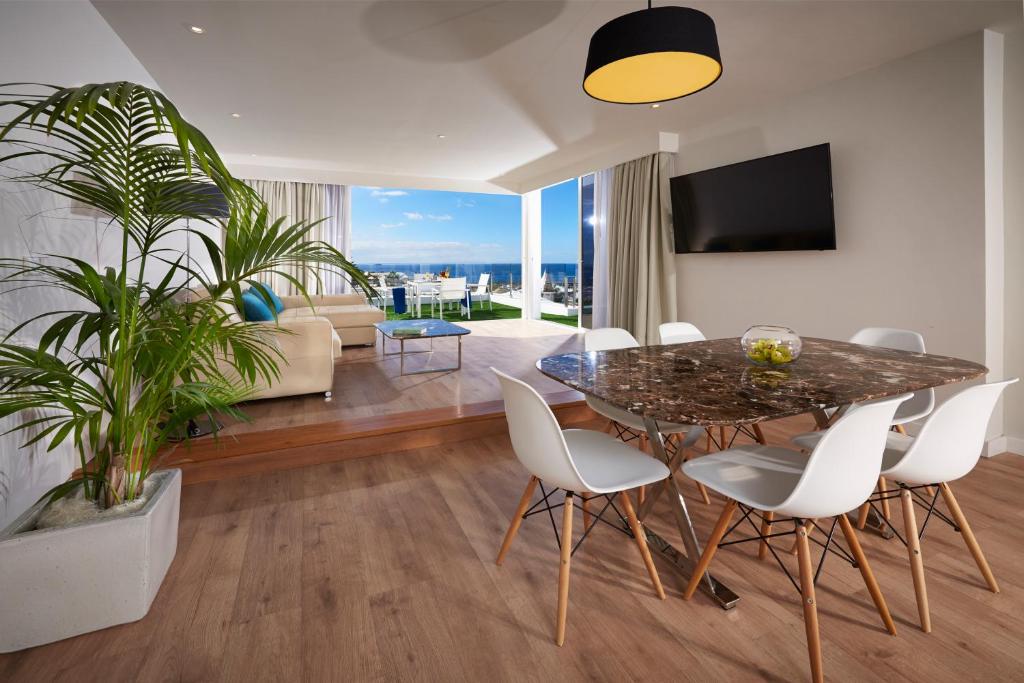 a dining room with a table and chairs and a living room at Flamingo Beach Mate in Adeje
