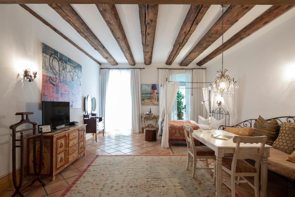 ein Wohnzimmer mit Tisch und Couch in der Unterkunft Hotel Orphée Andreasstadel in Regensburg