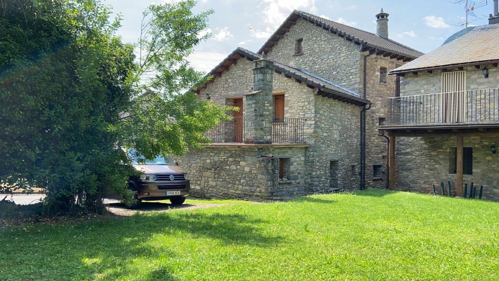 un coche aparcado frente a una casa de piedra en CASA SUERTES-FISCAL, en Fiscal