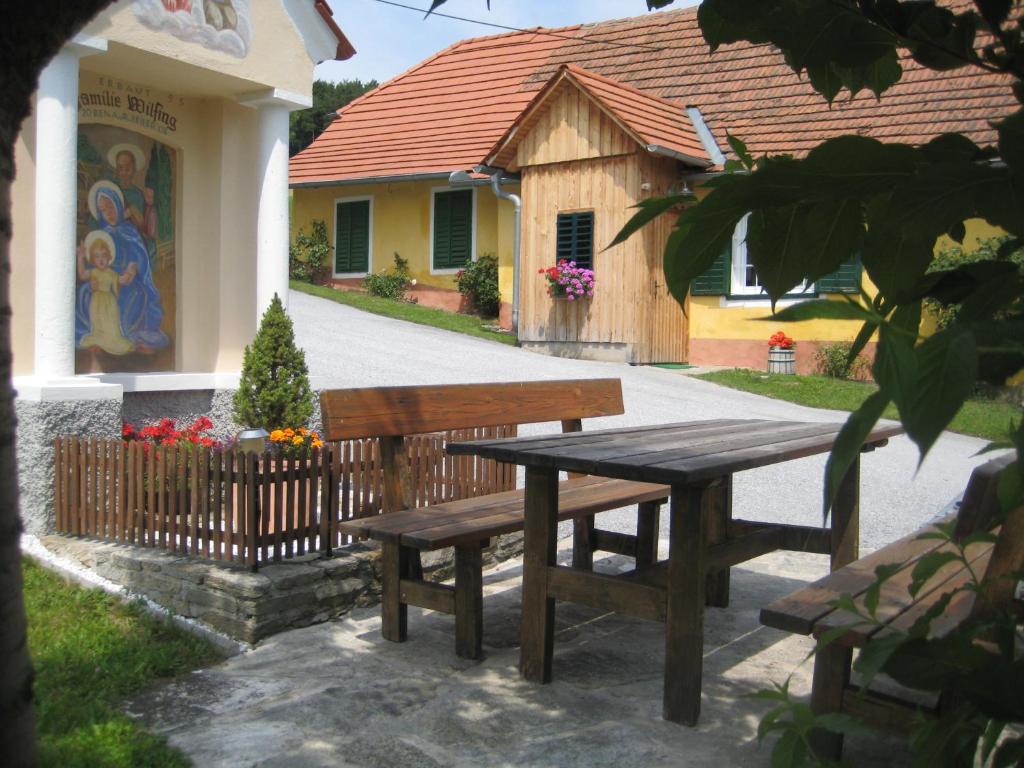 a picnic table and bench in front of a building at Hof Zaunfranzl in Stubenberg