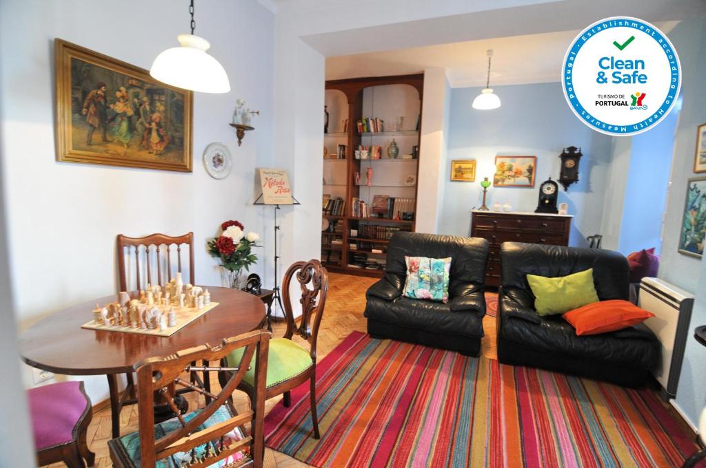 uma sala de estar com uma mesa e um sofá em Casa do Jardim em Silves