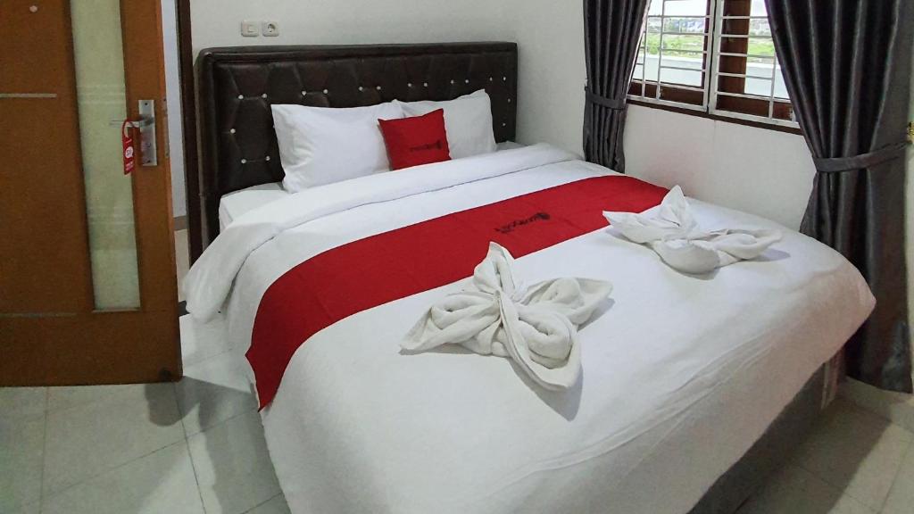 a bedroom with a bed with white towels on it at RedDoorz near CitraLand Gama City Medan in Pulauberayan Dadap