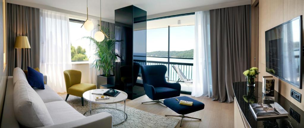 a living room with a white couch and chairs at Hotel Excelsior in Dubrovnik