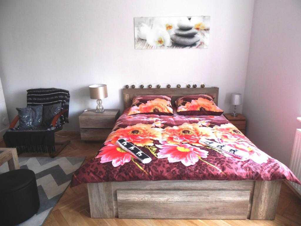 - une chambre dotée d'un lit avec un couvre-lit floral dans l'établissement Apartament Orchidea, à Cracovie
