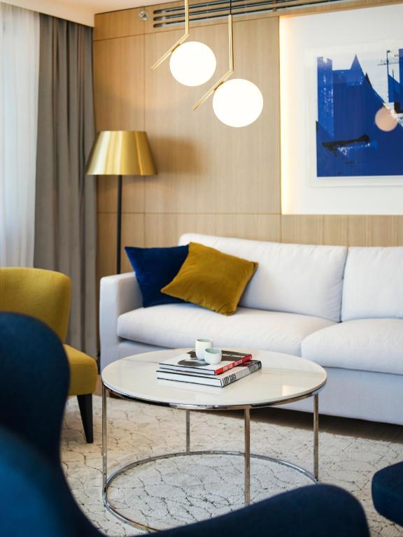 a living room with a white couch and a table at Hotel Excelsior in Dubrovnik