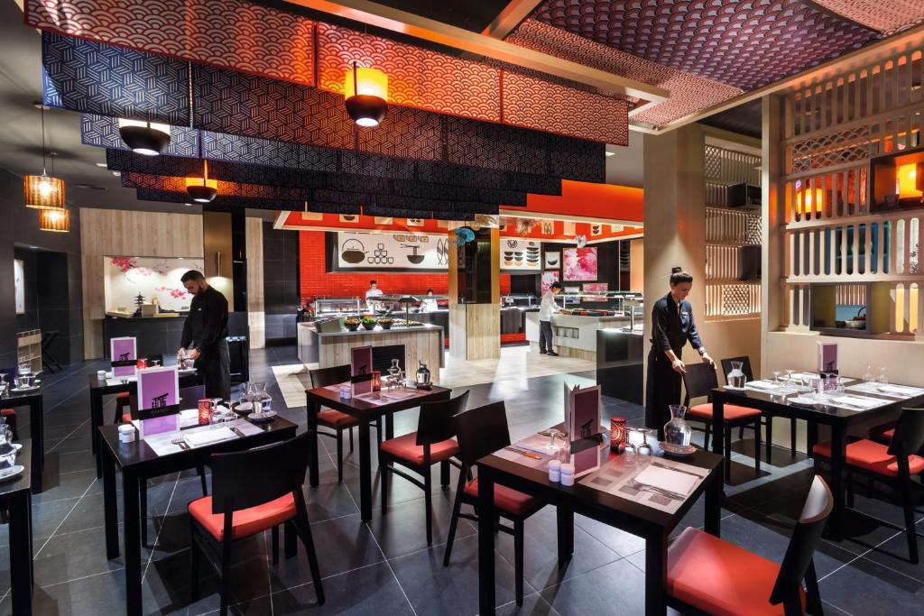 a restaurant with tables and people standing in the dining room at Hotel Riu Vistamar Gran Canaria - All Inclusive in Puerto Rico de Gran Canaria