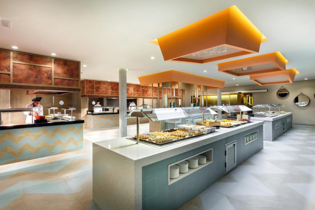 a large kitchen with a buffet line with food at Hotel Riu Vistamar Gran Canaria - All Inclusive in Puerto Rico de Gran Canaria