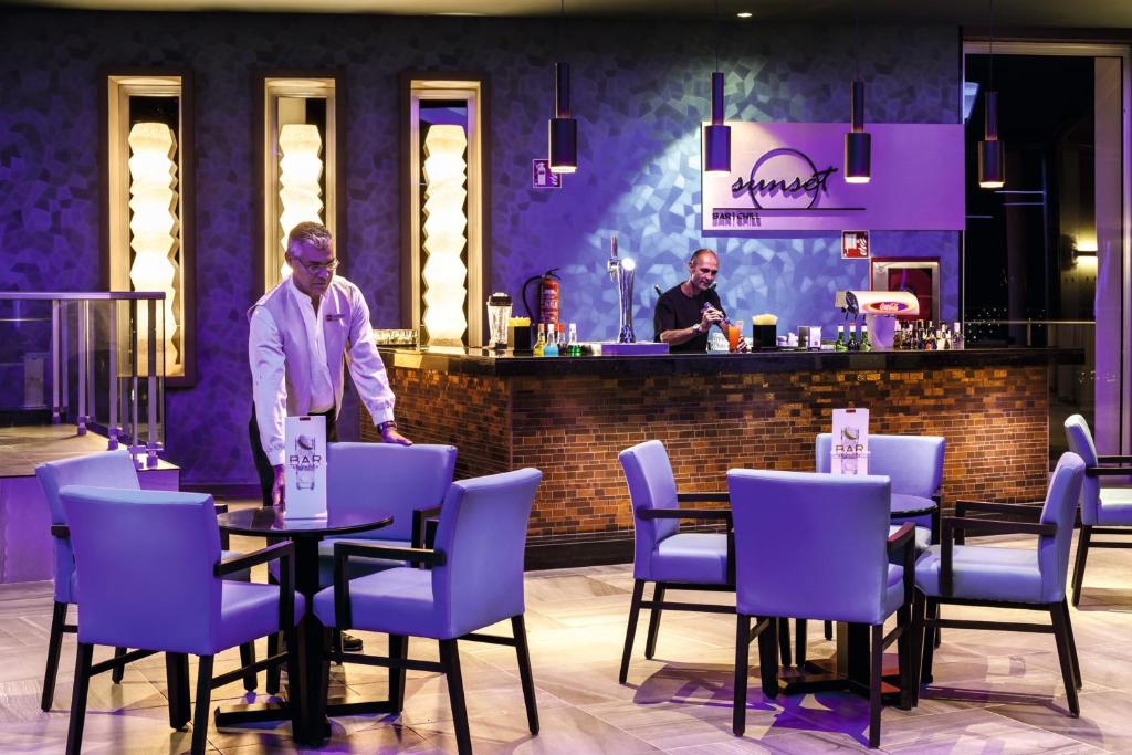 a man standing at a table in a restaurant at Hotel Riu Vistamar Gran Canaria - All Inclusive in Puerto Rico de Gran Canaria