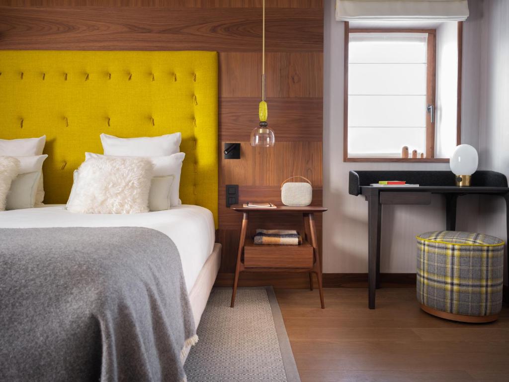 a bedroom with a bed and a yellow headboard at Coeur de Megève in Megève