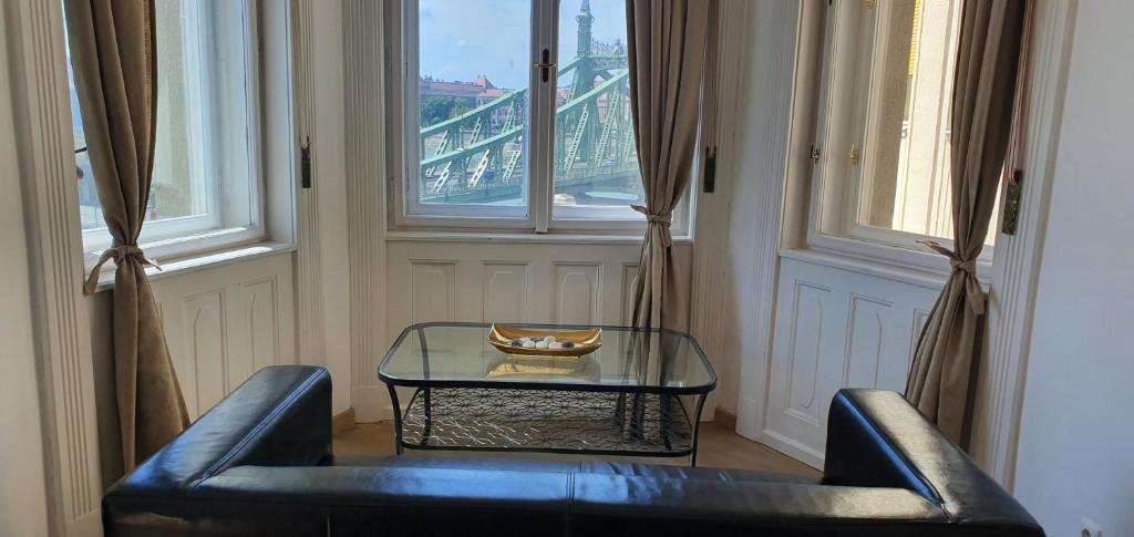 a living room with a glass table and a couch at Butterfly Home Danube in Budapest
