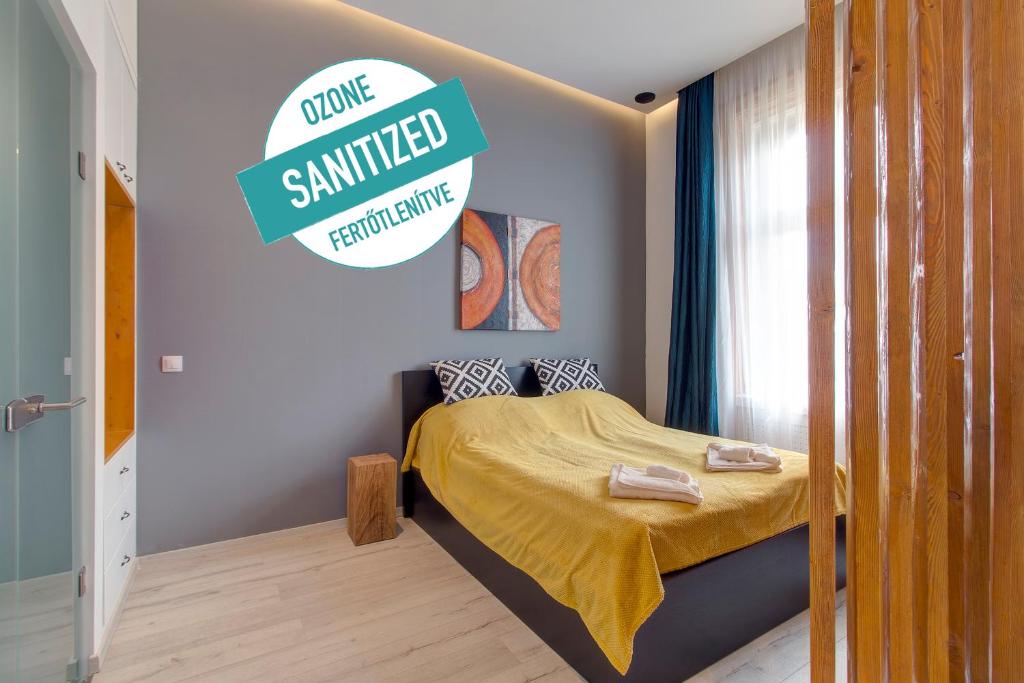 Dormitorio pequeño con cama con colcha amarilla en Luxury Apartment by Hi5 -Andrássy Suite, en Budapest