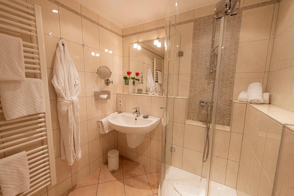 a bathroom with a shower and a sink and a toilet at Strandhotel Fontana in Timmendorfer Strand
