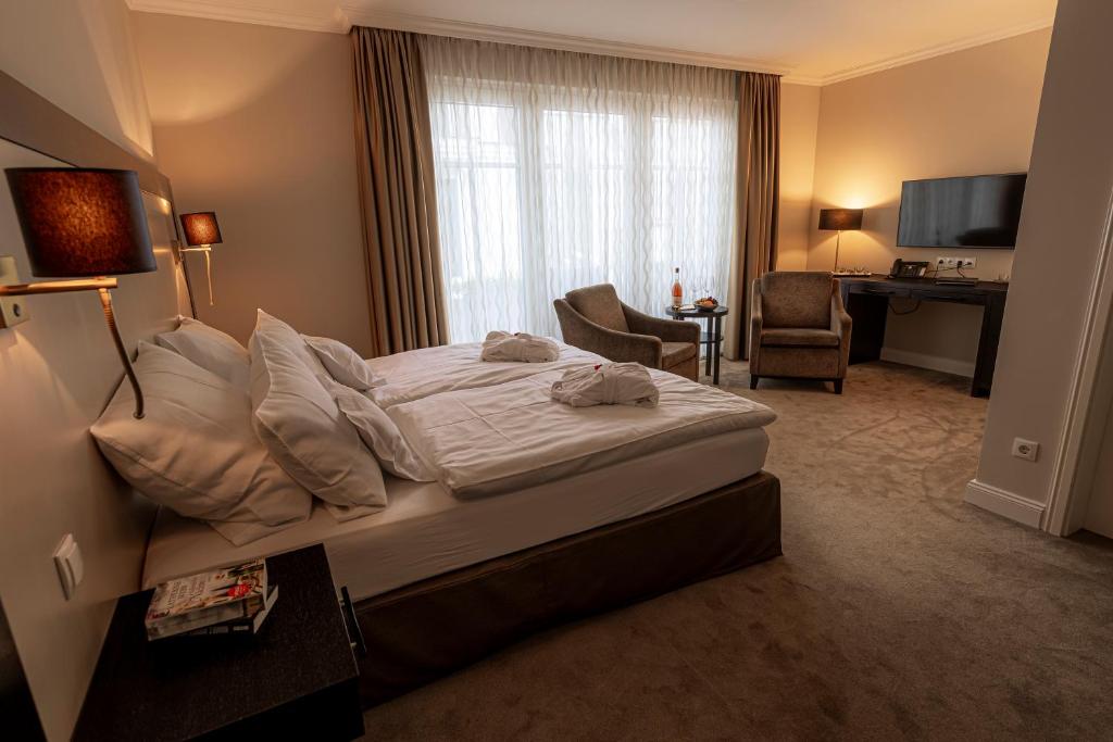 a bedroom with a bed and a desk in a room at Strandhotel Fontana in Timmendorfer Strand