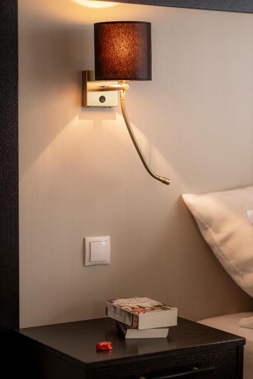 a lamp on a table next to a bed at Strandhotel Fontana in Timmendorfer Strand