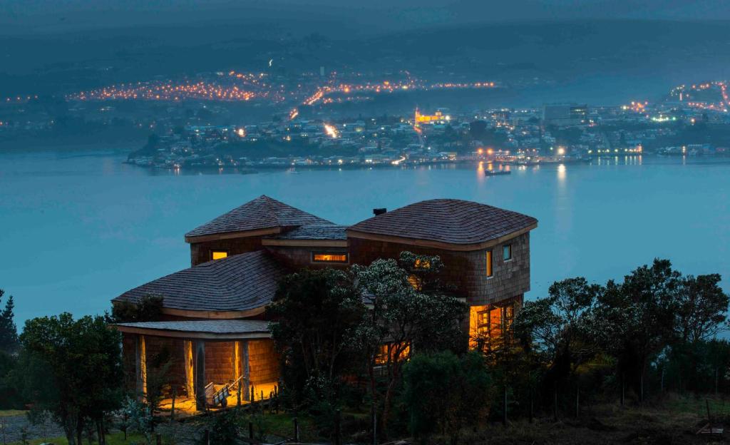una casa en el borde de un lago por la noche en OCIO Territorial Hotel, en Castro