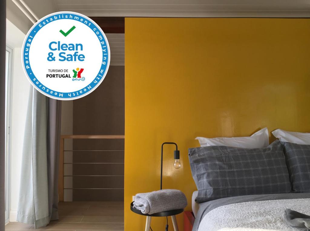 1 dormitorio con cama y pared amarilla en Villa Várzea Design Nest en Várzea