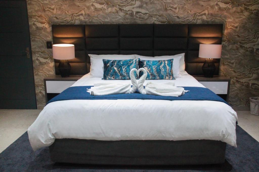 a bedroom with a large bed with a bow on it at The Cato Suites Hotel in Durban