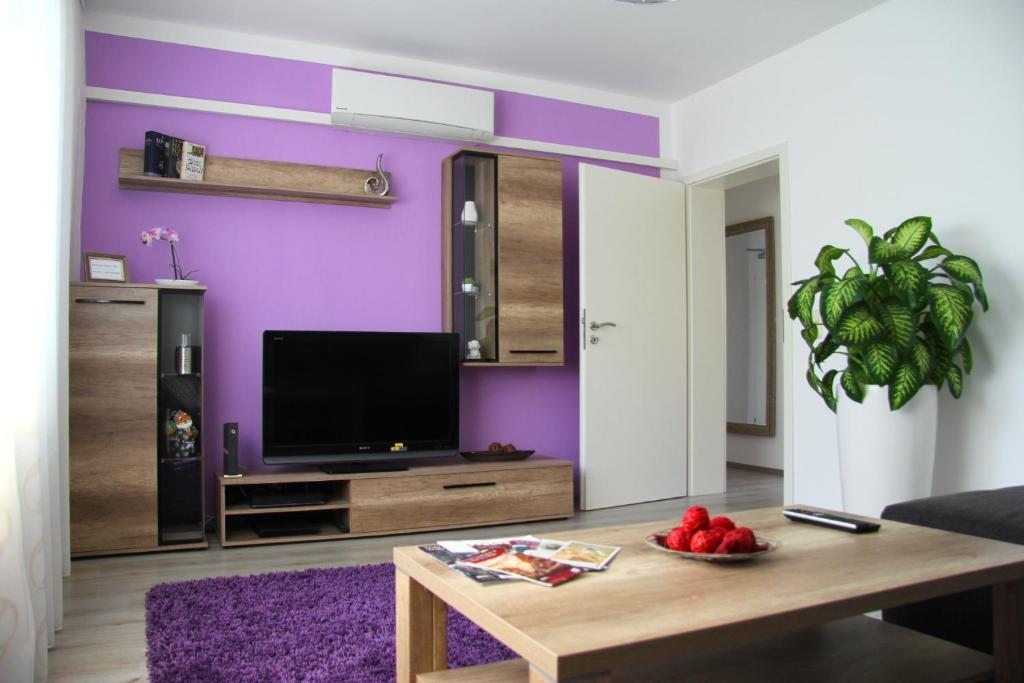 a living room with purple walls and a table at Geräumige 4 Zimmer Wohnung an den Kaiserthermen in Trier