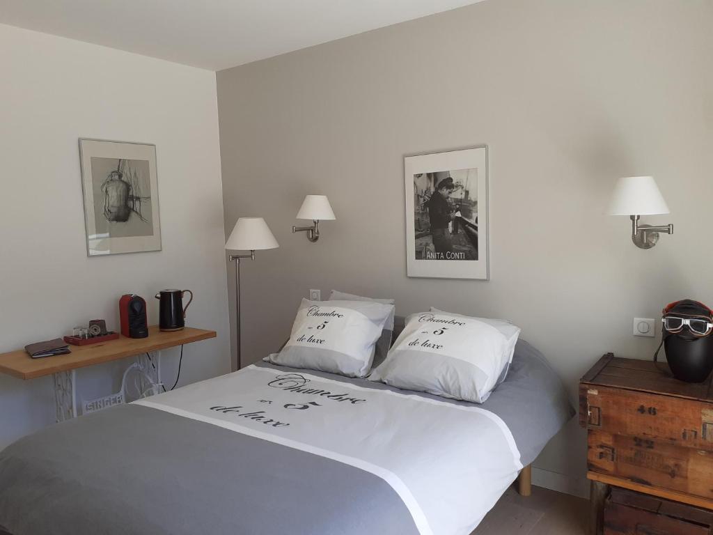 a bedroom with a bed with two pillows on it at ESCAPADE AU COEUR DE LA RIVIERA BRETONNE in La Forêt-Fouesnant