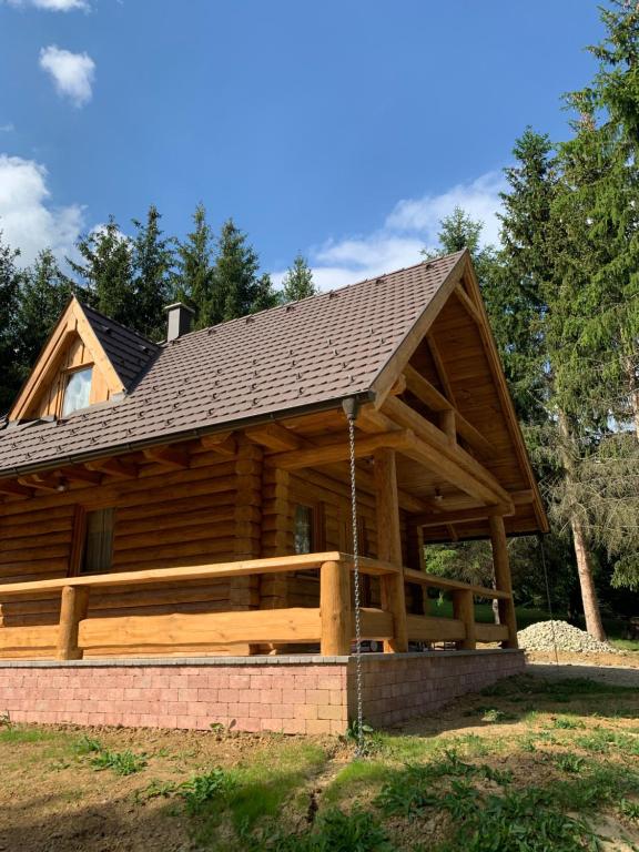 una cabaña de madera con techo de gambrel en Gyurka Kisrönkház, en Ispánk