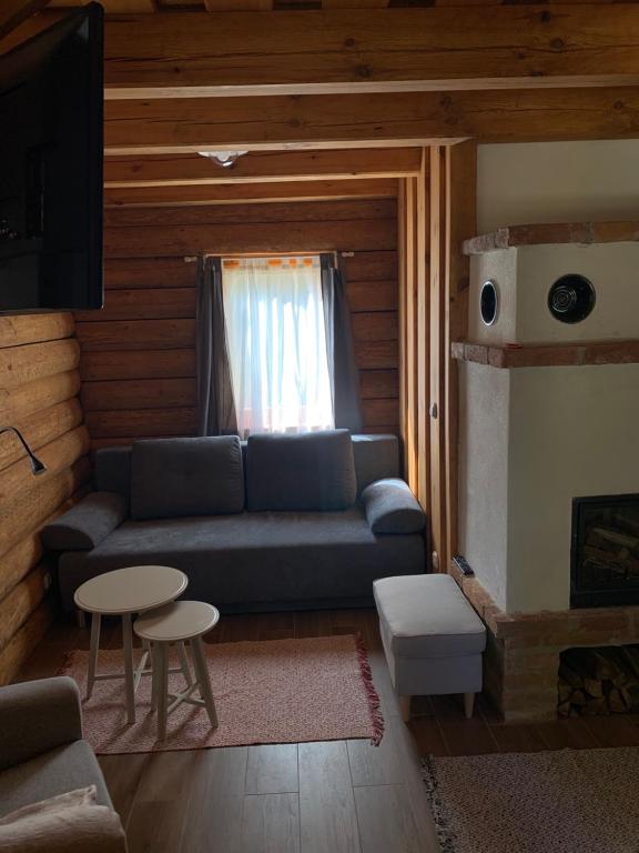 salon z kanapą i oknem w obiekcie Gyurka Kisrönkház w mieście Ispánk