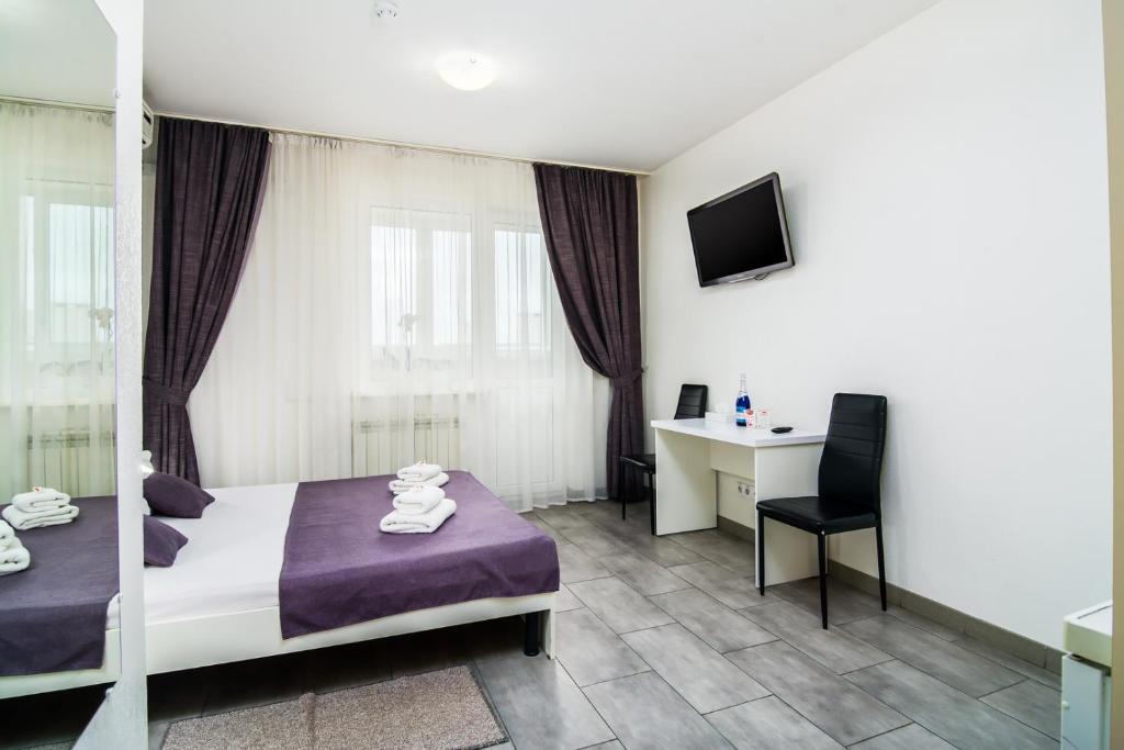 キーウにあるSkyHome Mini-hotelのベッドとデスクが備わるホテルルームです。