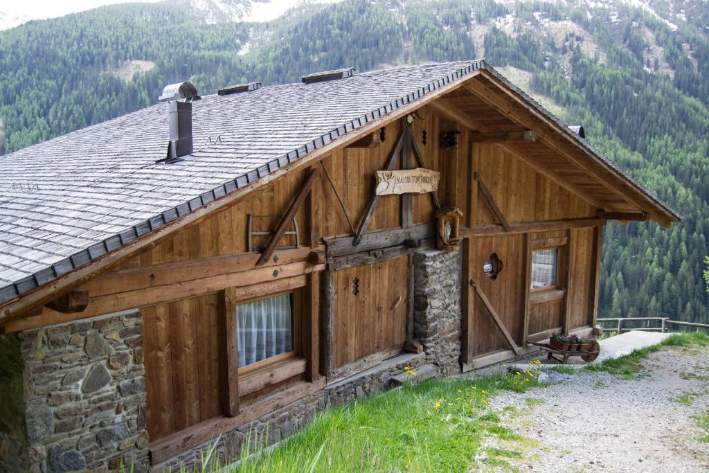 una cabaña de madera en las montañas con techo de pizarra en Chalet Mas del Toni, en Rabbi