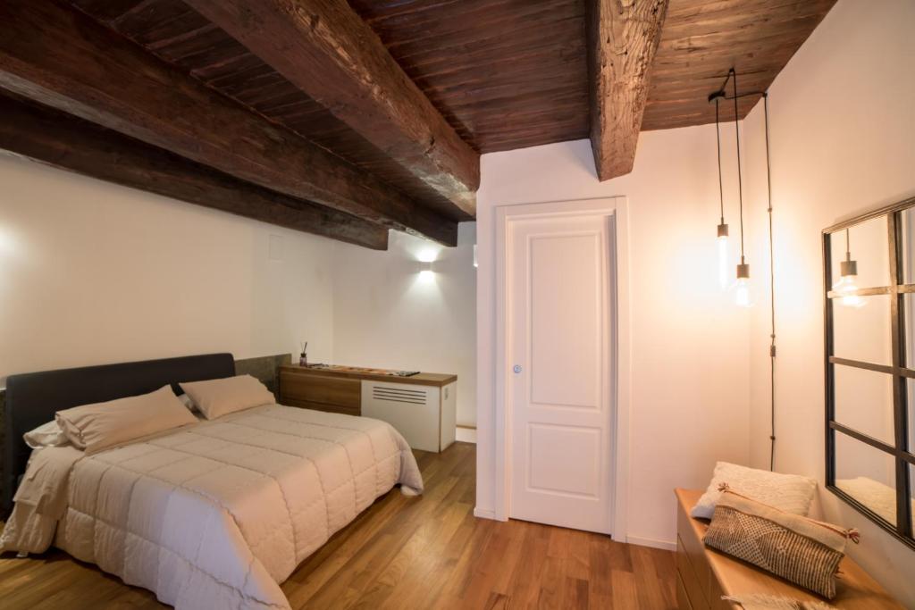 ナポリにあるCorte Capomazza Appartamentiの白いベッドと木製の天井が備わるベッドルーム1室が備わります。
