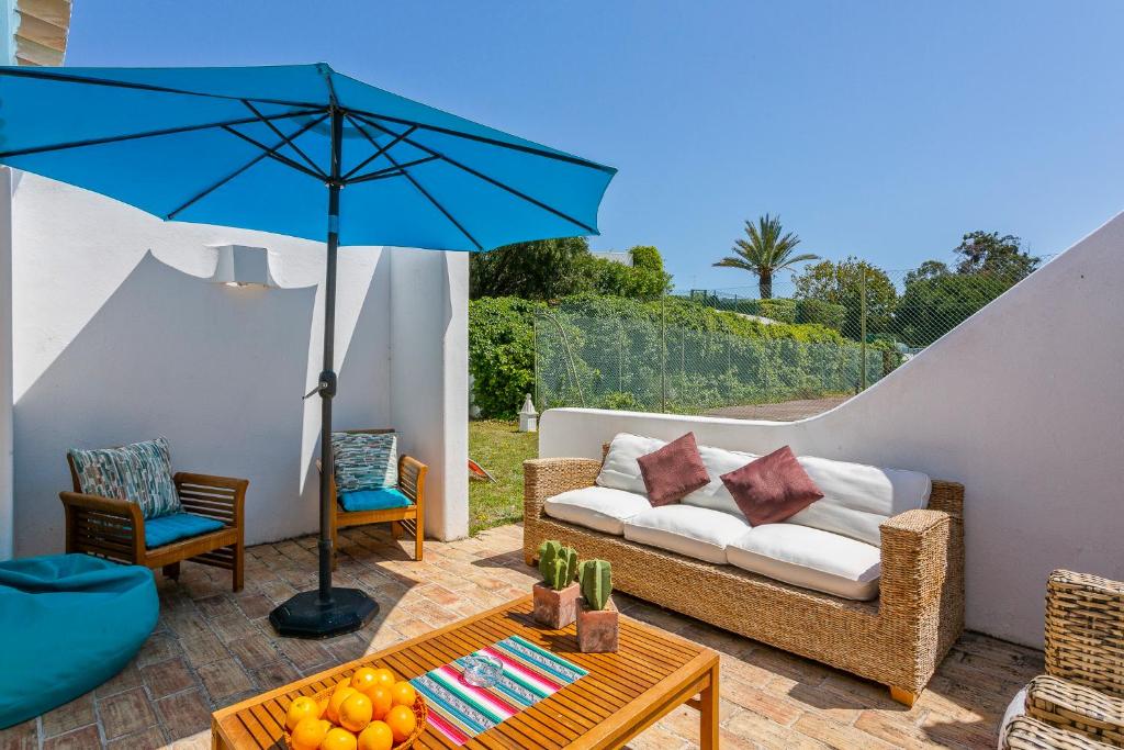 a patio with a couch and an umbrella at Villa in Quinta da Balaia in Albufeira