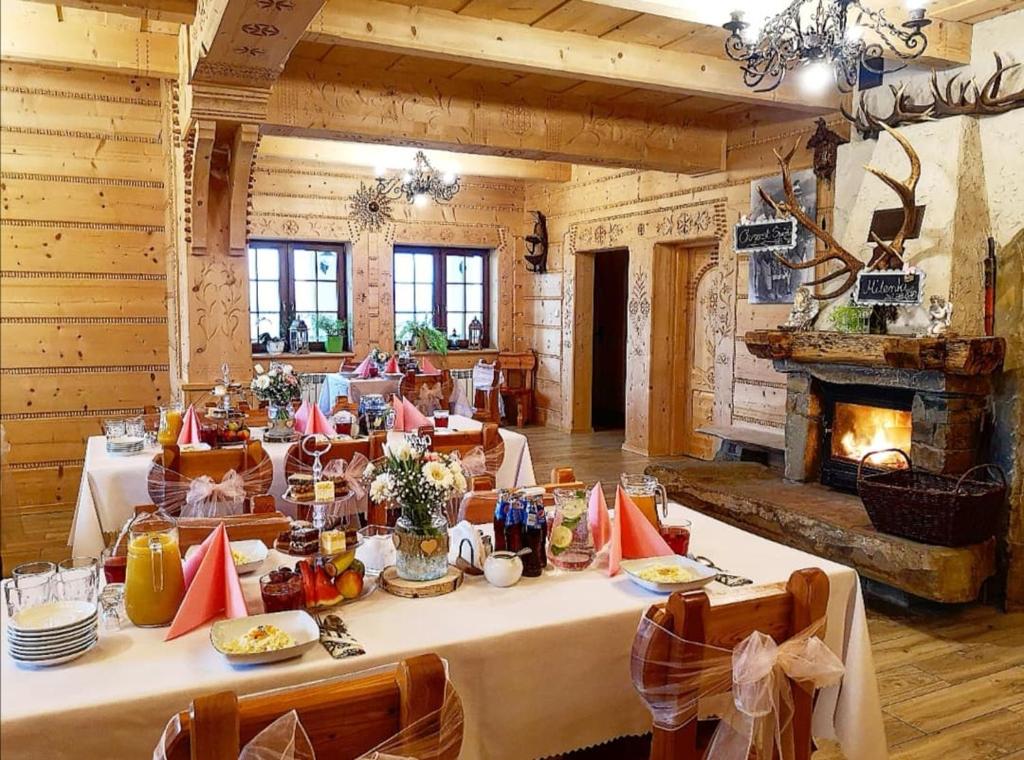 a dining room with a table and a fireplace at Przystań w Rzepiskach in Rzepiska