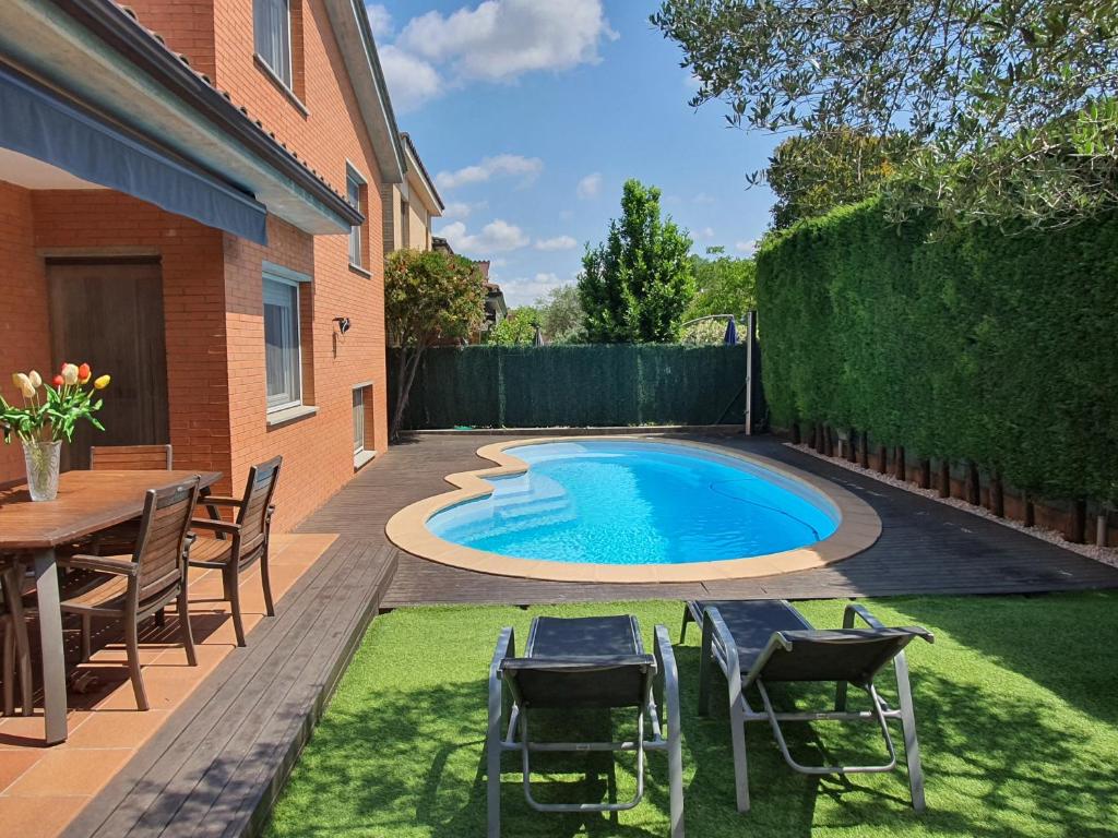 una piscina en un patio trasero con sillas y mesa en Nice Home, en Borgoñá