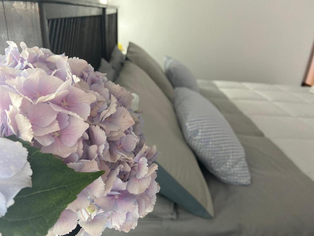 un mazzo di cuscini seduti su un letto con fiori di Gio House Pompei a Pompei