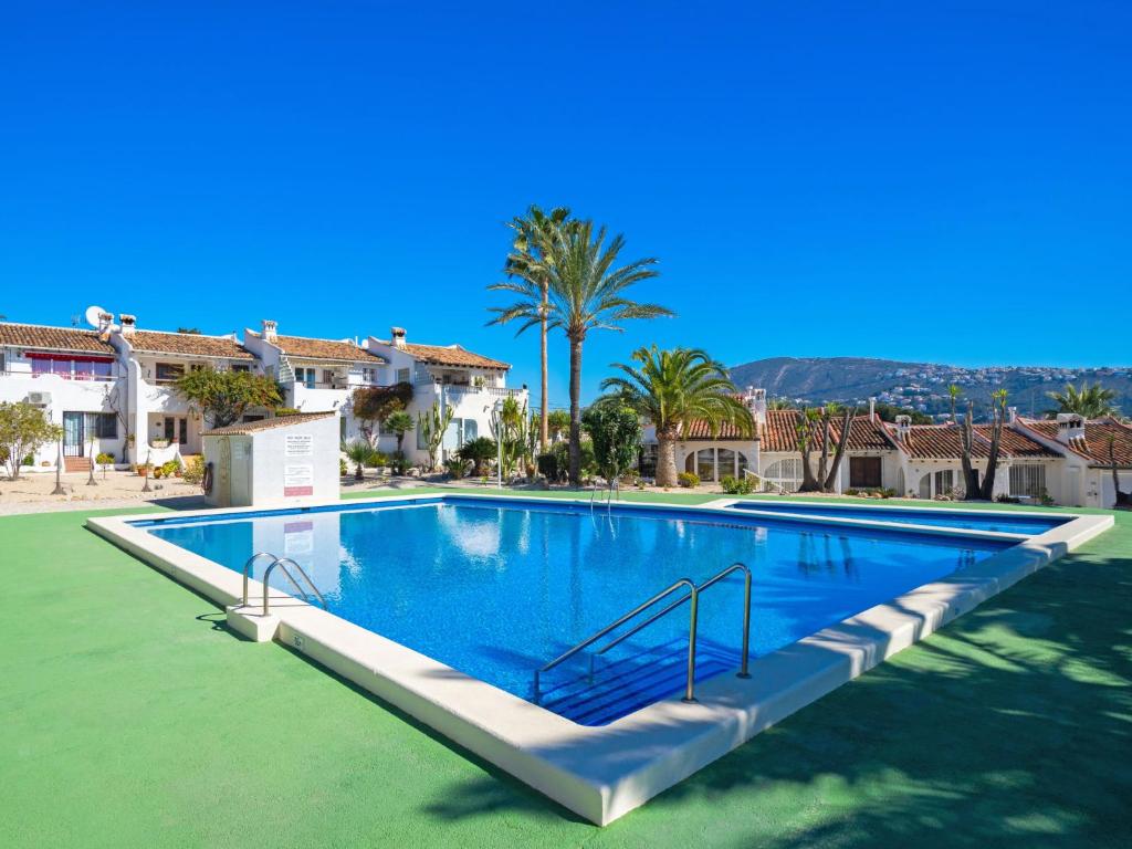 een groot zwembad in een villa met palmbomen bij Holiday Home La Camarrocha by Interhome in Moraira