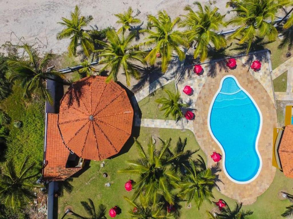 einen Blick über einen Regenschirm und einen Pool in der Unterkunft Pousada E Restaurante Doce Desejo in Ilhéus