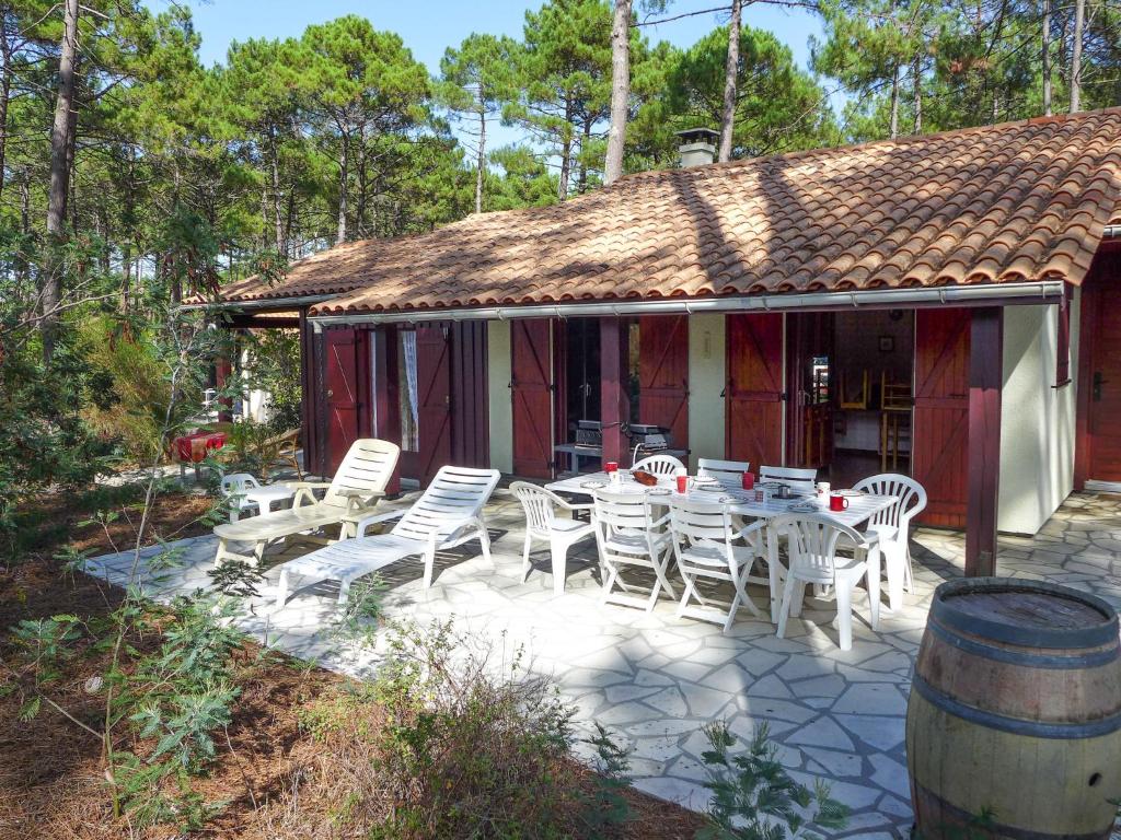 un patio avec une table et des chaises devant une maison dans l'établissement Holiday Home Les Sylvaines by Interhome, à Carcans