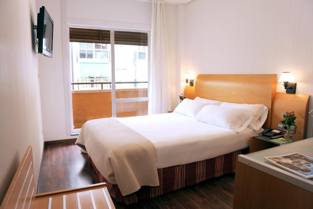 a hotel room with a bed and a window at Hotel El Churra in Murcia