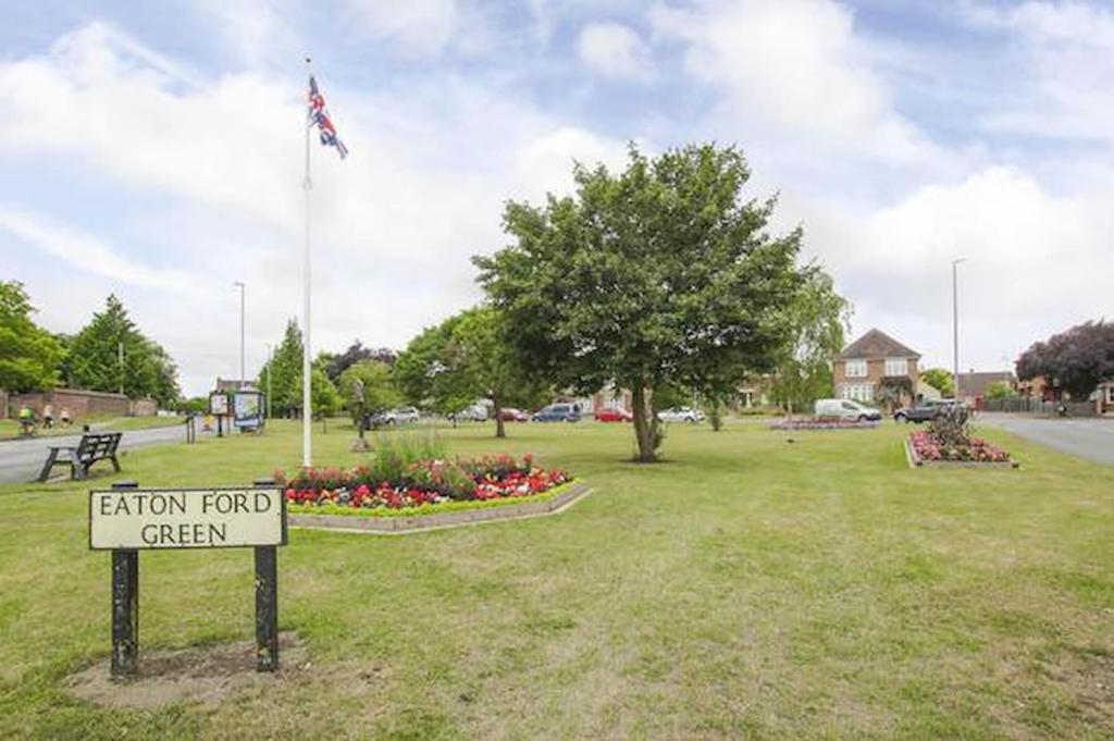 ein Schild in einem Park mit einem Schild für das Feld in der Unterkunft Eaton Ford Green Apartment in Saint Neots