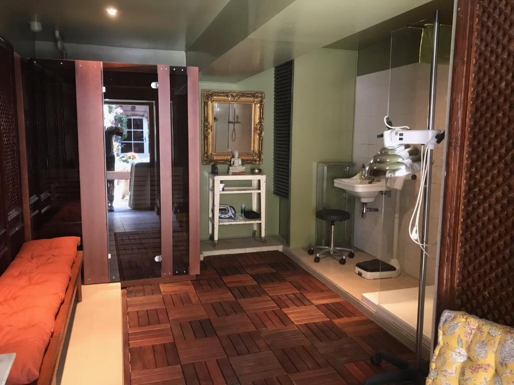 ein Wohnzimmer mit Holzboden und einem Spiegel in der Unterkunft B&B du Cloître in Tréguier
