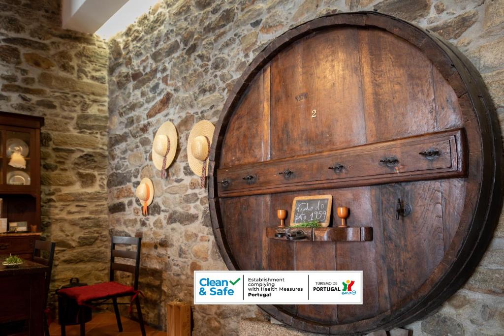 a large wooden barrel on the wall of a room at Casa do Vale 2 in Peso da Régua