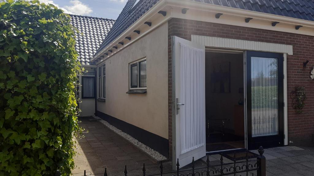 a side view of a house with a door at 2 persoons appartement Le Garage in Frieschepalen