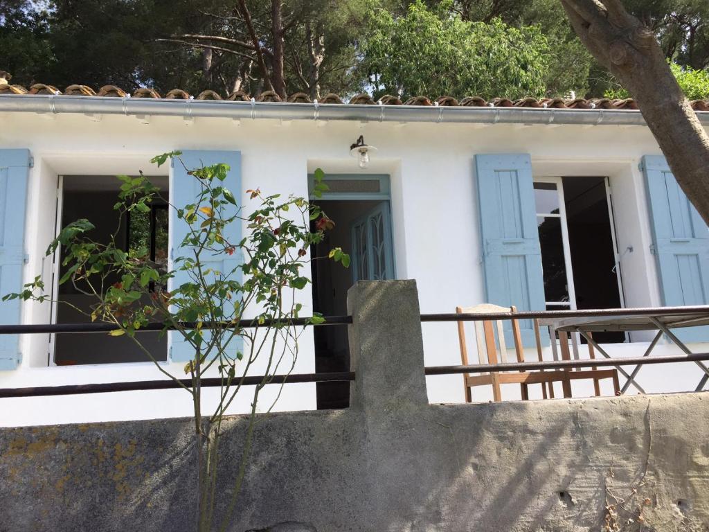 ein Haus mit blauen Türen und einem Zaun in der Unterkunft La Baraquette in Sète